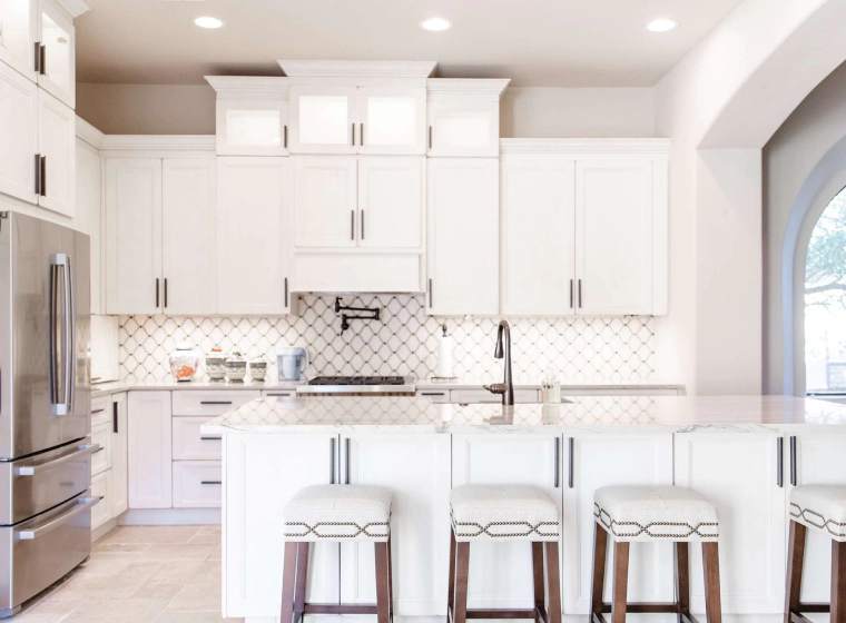white kitchen with a white countertop and chairs
